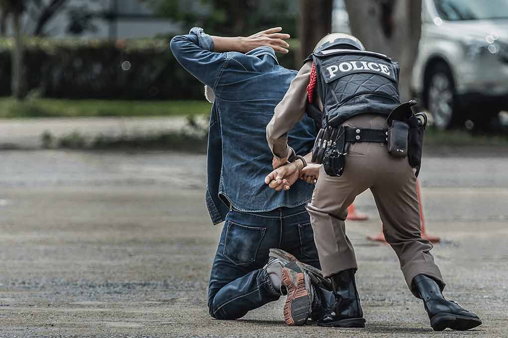 Полицейский надел наручники. Полиция надевает наручники. Полицейский одевает наручники. Полицейский надевает наручники задержанному. Полиция пристегивает наручники.