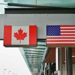 Canadian and American flags outside building structure