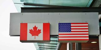 Canadian and American flags outside building structure