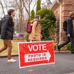 New Republican Legislation Aims to Strengthen Voting Integrity Measures People walking into building beside "Vote" sign.