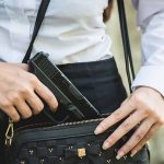 Exploring Cornyn’s Concealed Carry Bill and Independent Journalism’s Role Person placing gun into a handbag.