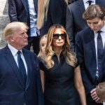 People standing together outdoors in formal attire.