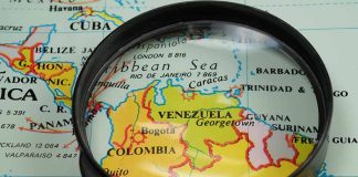 Magnifying glass over a map of Venezuela.