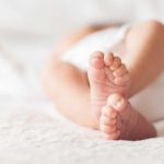 Close-up of baby feet lying on blanket.