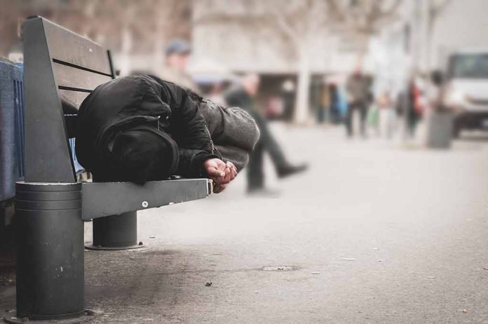1016111287 featured image Person sleeping on a bench in a public area.