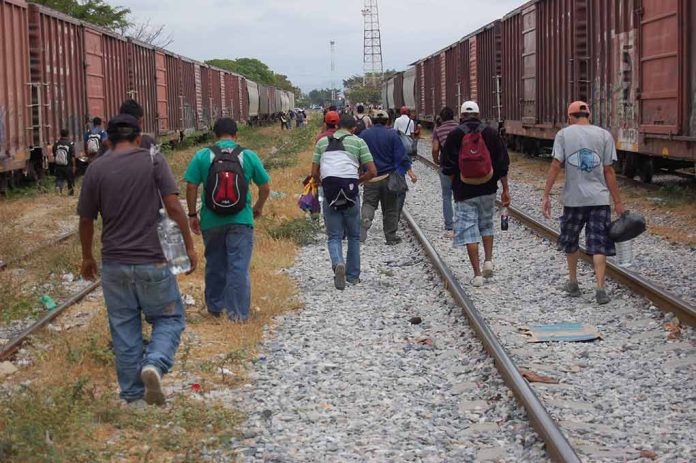 1119750086 featured image People walking along train tracks carrying backpacks