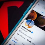 Elon Musk Faces New Business Hurdles Amid Various Controversies Phone screen showing Twitter profile with spacescapes.