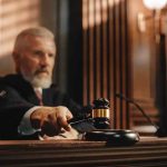 Judge holding gavel in courtroom.