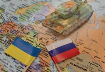 Ukraine and Russia flags with toy tank on map
