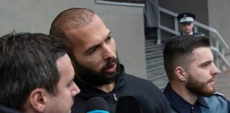 Group of men with microphones outside a building