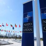 European Leaders Back Trump’s Call for Higher NATO Defense Spending NATO flags and banners under clear sky.