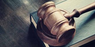 Wooden gavel resting on thick book