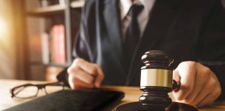 Person in suit with gavel at desk