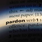 The word pardon highlighted in a dictionary.