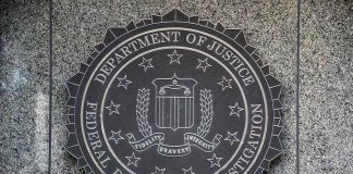 FBI seal on granite wall displaying department motto