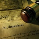 Gavel resting on First Amendment document background