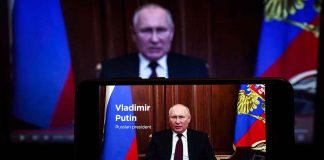 Man speaking on screen with Russian flag background.