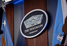 Pentagon emblem between two flags in Washington office