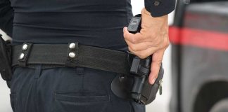 Person holding a gun in a holster.