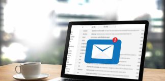 Laptop with email notification near cup of coffee