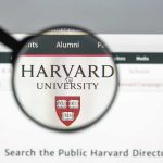Magnifying glass over Harvard University webpage text and logo