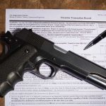 Gun and pen on firearm transaction form