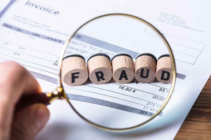 Magnifying glass showing FRAUD on an invoice