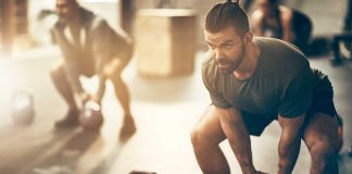 Man lifting kettlebell in a gym setting
