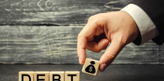 Hand replacing debt block with money symbol block