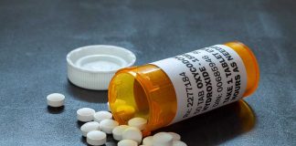 Pills spilled from orange prescription medicine bottle