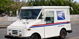 USPS mail truck driving down the street