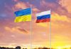 Ukrainian and Russian flags against sunset sky