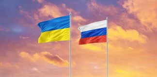 Ukrainian and Russian flags against sunset sky