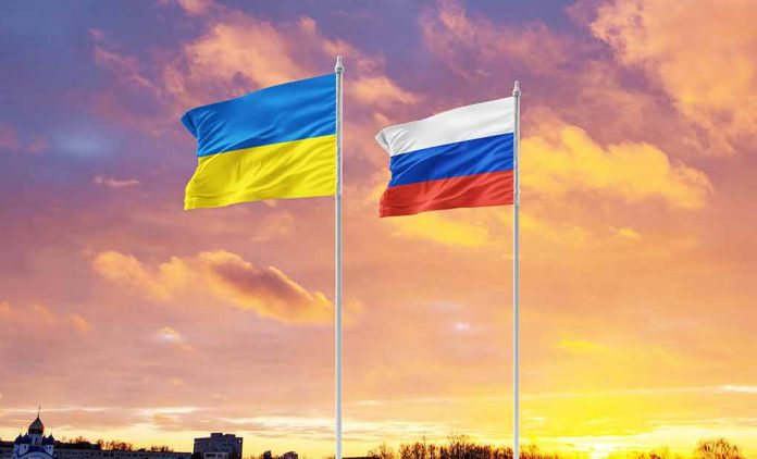 Ukrainian and Russian flags against sunset sky