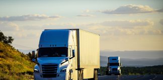 Two semitrucks driving on a highway
