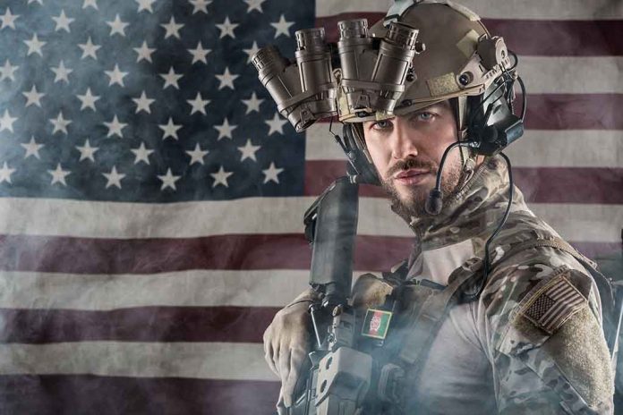 Soldier in gear standing in front of American flag