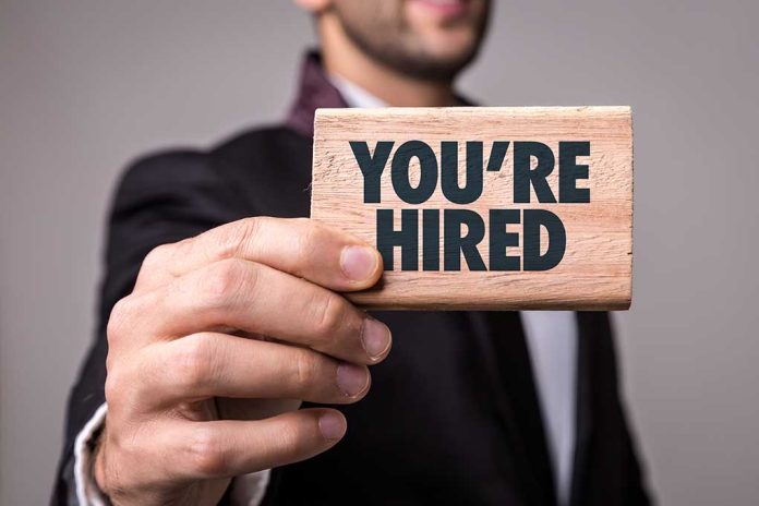 623590175 featured image Person holding a You're Hired sign