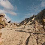 Soldiers running on rocky terrain with backpacks