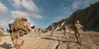 Soldiers running on rocky terrain with backpacks