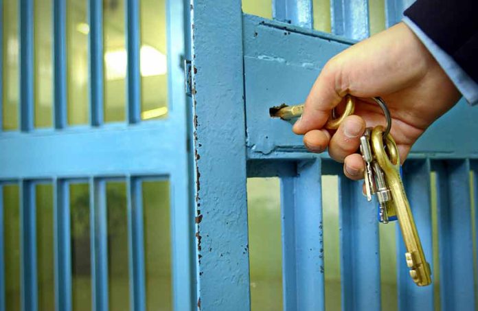 789621847 featured image Hand unlocking blue prison cell with keys