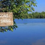 Sign saying Gone Fishing by a lake