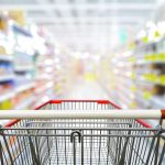 Shopping cart in aisle of grocery store