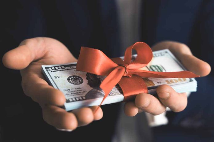 Hands holding stack of hundred dollar bills with ribbon