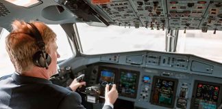 Pilot in cockpit operating airplane controls