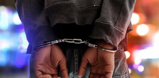 Person in handcuffs with colorful lights in background