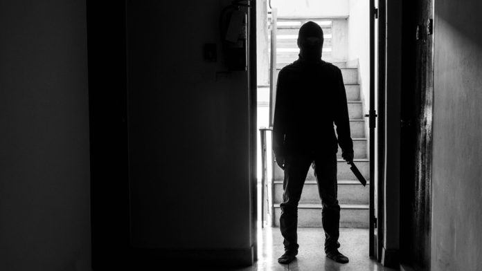 771108136 featured image Silhouette of person with knife in dimly lit hallway