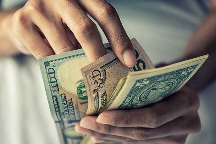 Person holding multiple US dollar bills