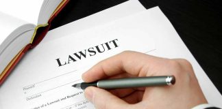 Filling out lawsuit form with pen