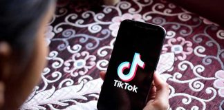 Hand holding phone showing TikTok logo