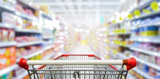 Shopping cart in aisle of grocery store